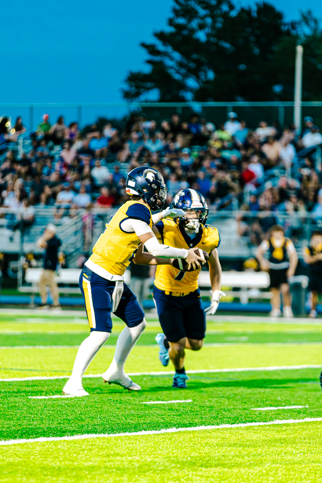 Two Warriors players exchanging the ball in front of the crowd